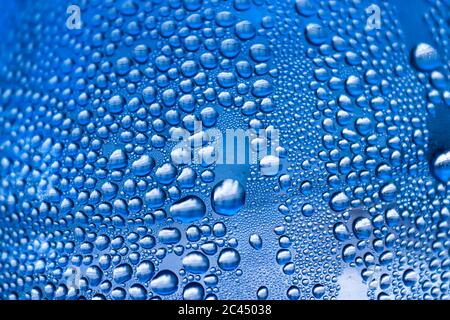 Makroerfassung von empfindlichen blauen Wassertropfen glänzt auf einer Glasoberfläche