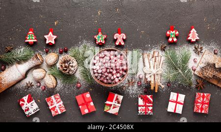 Banner mit Konzept Weihnachten und Neujahr. Zutaten zum Backen, Weihnachtsbaumschmuck und Geschenkschachteln auf dunklem Hintergrund, Draufsicht, Kopie Stockfoto