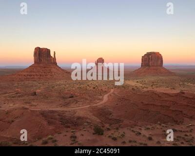 Tolle Aussicht auf Monument Valley mit roter Wüste und blauem Himmel und Wolken am Morgen. Monument Valley in Arizona mit West Mitten Butte, East Mitten Stockfoto