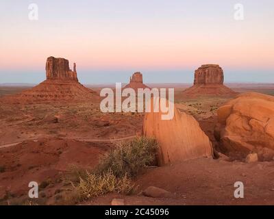 Tolle Aussicht auf Monument Valley mit roter Wüste und blauem Himmel und Wolken am Morgen. Monument Valley in Arizona mit West Mitten Butte, East Mitten Stockfoto