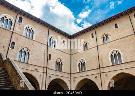 1. Juni 2019 - Foligno, Perugia, Umbrien, Italien - der Innenhof und die gotische Treppe des antiken Trinci Palastes. Ziegelmauer, Fenster, Bögen und Stockfoto