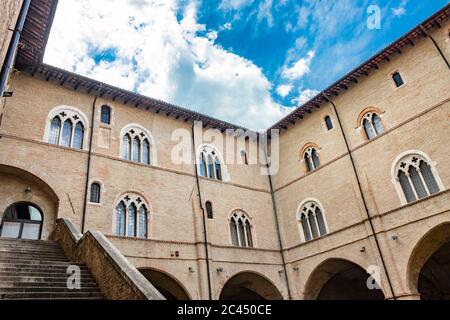 1. Juni 2019 - Foligno, Perugia, Umbrien, Italien - der Innenhof und die gotische Treppe des antiken Trinci Palastes. Ziegelmauer, Fenster, Bögen und Stockfoto