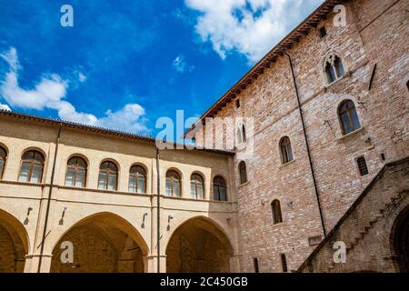 1. Juni 2019 - Foligno, Perugia, Umbrien, Italien - der Innenhof und die gotische Treppe des antiken Trinci Palastes. Ziegelmauer, Fenster, Bögen und Stockfoto