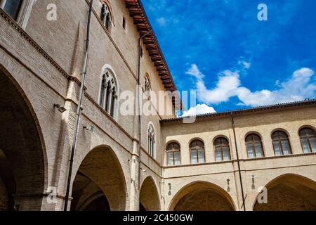 1. Juni 2019 - Foligno, Perugia, Umbrien, Italien - der Innenhof und die gotische Treppe des antiken Trinci Palastes. Ziegelmauer, Fenster, Bögen und Stockfoto