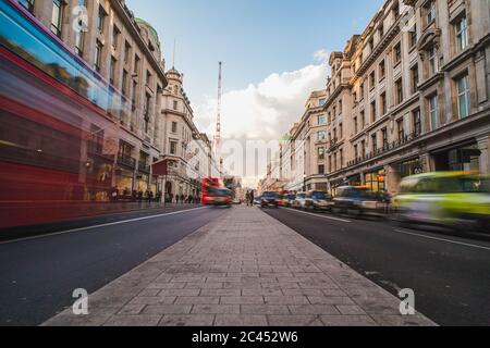 LONDON, Großbritannien - 24. MÄRZ 2015: Blick auf die Regent Street während des Tages, mit Geschäften, Gebäuden und der Unschärfe von Menschen und Verkehr Stockfoto