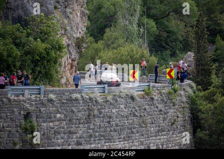 Skradin Kroatien, Juni 2020 Rot und schwarz Mitsubishi Lancer Abstieg vom Hügel während eines Rennens, aus der Ferne gesehen, versammelten sich die Menschen entlang der Straße Stockfoto