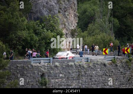 Skradin Kroatien, Juni 2020 Rot und schwarz Mitsubishi Lancer Abstieg vom Hügel während eines Rennens, aus der Ferne gesehen, versammelten sich die Menschen entlang der Straße Stockfoto