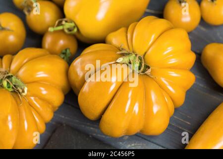 Mischen Tomaten Hintergrund. Mehrere Sorten von Tomaten am Sommertag. Verschiedene Arten sortiert bunte gelbe Tomaten. Stockfoto