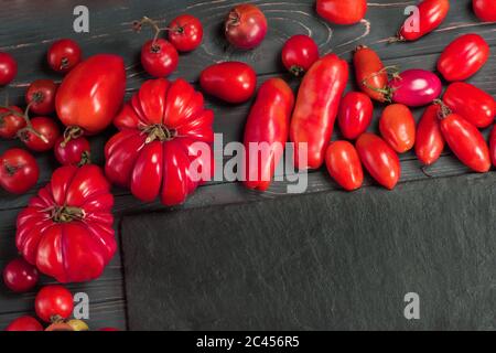 Die Ernte der Mischung Tomaten. Verschiedene bunte Tomaten. Tomaten sind verschiedene Sorten. Mischen Tomaten Hintergrund Stockfoto