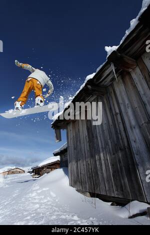 Snowboarder springt über eine Scheune in Hochfügen, Tirol, Österreich Stockfoto