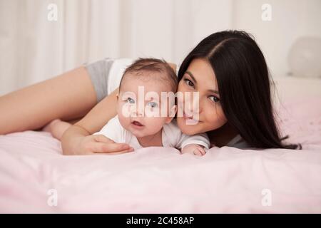 Mutter liegt im Bett mit Baby, Porträt Stockfoto