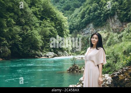 Porträt eines jungen Erwachsenen schöne kasachische Mädchen am Flussufer auf einem Hintergrund der Natur. Stockfoto