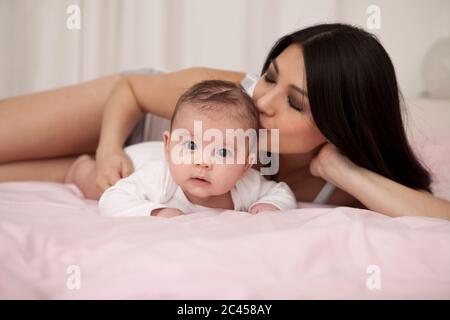 Mutter liegt im Bett mit Baby Stockfoto