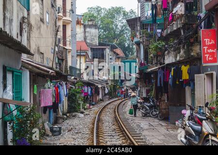HANOI, VIETNAM - 19. MÄRZ 2017: Ein Blick auf Bahngleise, die durch die Stadt Hanoi führen. Die Außenseite von Gebäuden und Menschen ist entlang t zu sehen Stockfoto