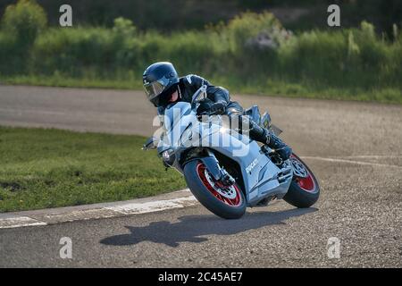 Motorradfahrer bei Sportfahrrad Fahrten durch leere Asphaltstraße. Sportfahrrad. Stockfoto