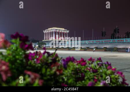 HANOI, VIETNAM - 19. MÄRZ 2017: Die Außenseite des Ho Chi Minh Mausoleums in Hanoi bei Nacht. Die vietnamesische Flagge kann im Wind vor wehen. Stockfoto