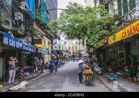 HANOI, VIETNAM - 20. MÄRZ 2017: Blick auf die Straßen von Hanoi in Vietnam während des Tages. Die Außenseite von Gebäuden, Geschäften und Menschen ist zu sehen. Stockfoto