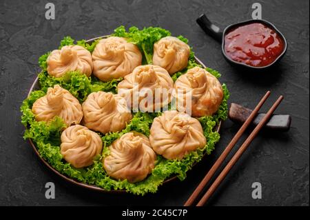 Veg Momos auf schwarzer Schieferplatte. Momos ist das beliebte Gericht der indischen, tibetischen, chinesischen Küche. Asiatische Küche. Vegetarisches Menü Stockfoto