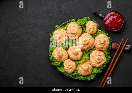 Veg Momos auf schwarzer Schieferplatte. Momos ist das beliebte Gericht der indischen, tibetischen, chinesischen Küche. Asiatische Küche. Vegetarisches Menü. Speicherplatz kopieren. Draufsicht Stockfoto