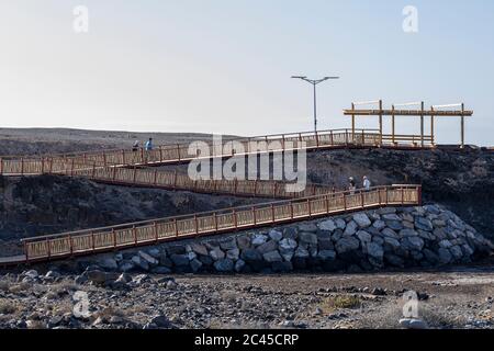 Menschen gehen auf der neuen Fußgängerbrücke von Los Abrigos zum Golf del Sur, wo es San Blas, Teneriffa, Kanarische Inseln, Spanien passiert Stockfoto