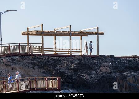 Menschen gehen auf der neuen Fußgängerbrücke von Los Abrigos zum Golf del Sur, wo es San Blas, Teneriffa, Kanarische Inseln, Spanien passiert Stockfoto