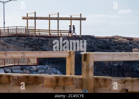 Menschen gehen auf der neuen Fußgängerbrücke von Los Abrigos zum Golf del Sur, wo es San Blas, Teneriffa, Kanarische Inseln, Spanien passiert Stockfoto