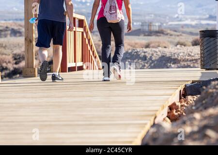 Menschen gehen auf der neuen Fußgängerbrücke von Los Abrigos zum Golf del Sur, wo es San Blas, Teneriffa, Kanarische Inseln, Spanien passiert Stockfoto