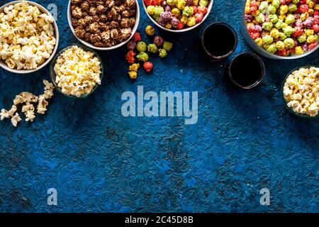 Set von aromatisiertem Popcorn und Soda auf blauem Tisch Draufsicht Kopierraum Stockfoto