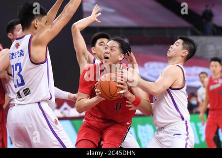 Dongguan, Chinas Provinz Guangdong. Juni 2020. Shen Zijie (C) von Shenzhen Aviators wird während eines Spiels zwischen Tianjin Pioneers und Shenzhen Aviators in der neu wiederaufgenommenen Liga der Chinesischen Basketballvereinigung (CBA) 2019-2020 in Dongguan, südchinesische Provinz Guangdong, am 24. Juni 2020 verteidigt. Quelle: Liang Xu/Xinhua/Alamy Live News Stockfoto