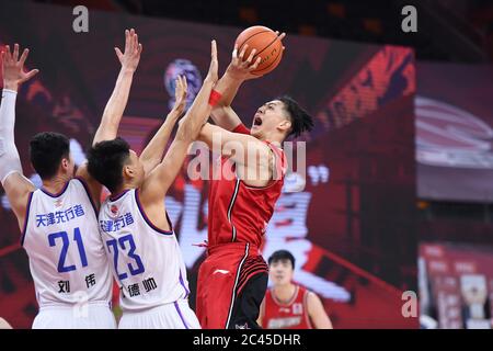 Dongguan, Chinas Provinz Guangdong. Juni 2020. Shen Zijie (R) von Shenzhen Aviators springt während eines Spiels zwischen Tianjin Pioneers und Shenzhen Aviators in der neu wiederaufgenommenen Liga der Chinesischen Basketballvereinigung (CBA) 2019-2020 in Dongguan, südchinesische Provinz Guangdong, 24. Juni 2020, um zu schießen. Quelle: Liang Xu/Xinhua/Alamy Live News Stockfoto