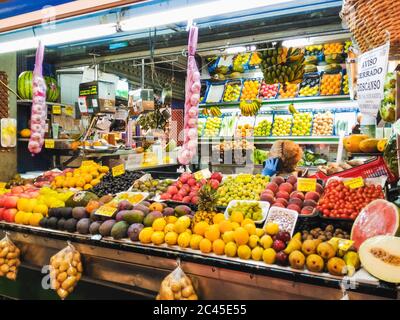 LAS PALMAS, SPANIEN - 05. Aug 2016: LAS PALMAS, KANARISCHE INSELN - 05. AUGUST 2016: Eine ältere Frau spricht auf ihrem Handy an ihrem Obststand in der Stockfoto