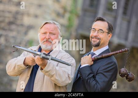 Grevenbroich, Deutschland. Juni 2020. EXKLUSIV - Jan Josef Liefers (r), Schauspieler, (als Karl-Friedrich Boerne) mit Morgenstern mit zwei Metallkugeln und Axel Prahl, Schauspieler, (als Frank Thiel) mit Armbrust, stehen vor Schloss Hülchrath während der Dreharbeiten zum neuen Tatort aus Münster. Ein Sendetermin für den Tatort mit dem Titel "Long Live The King" in der ARD ist noch nicht festgelegt. Quelle: Rolf Vennenbernd/dpa/Alamy Live News Stockfoto