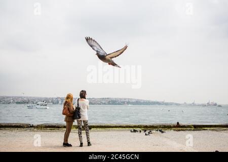 Zwei Frauen auf dem Bosporus mit fliegender Taube, Istanbul, Türkei Stockfoto