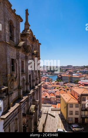 Porto, Portugal - 'Igreja dos Grilos / S. Lourenço' - Katholische Kirche aus hohem Stein in der Innenstadt mit traditionellen Häusern mit orangefarbenen Ziegeldächern Stockfoto