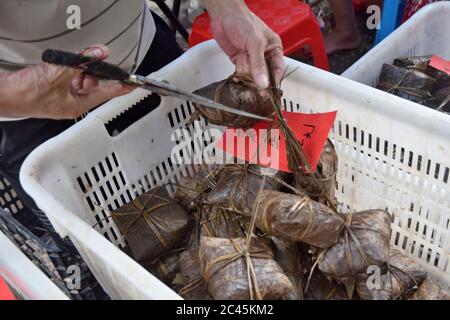 Ein Bündel Reisknödel, Zongzi, zusammengebunden. Zongzi ist ein traditionelles chinesisches Reisgericht aus klejeweidem Reis, der mit verschiedenen Füllungen gefüllt ist. Stockfoto
