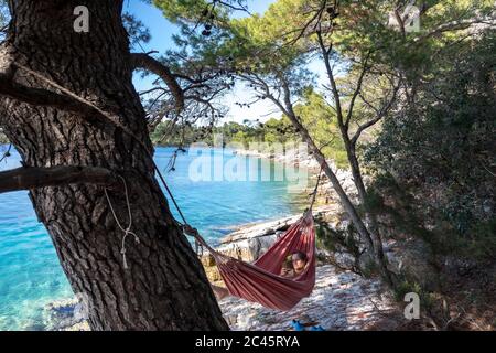 Frau liest in der Hängematte auf der Insel mljet, kroatien Stockfoto