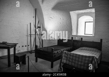 30. Juni 2019 - Narni, Umbrien, Italien - Innenräume der mittelalterlichen Burg, im alten Dorf Narni. Schlafzimmer mit Holzmöbeln. Stockfoto