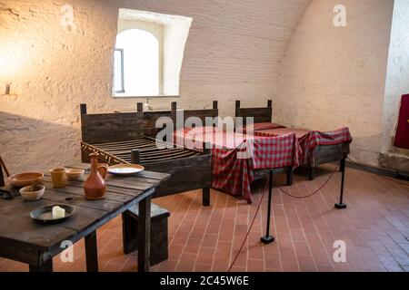 30. Juni 2019 - Narni, Umbrien, Italien - Innenräume der mittelalterlichen Burg, im alten Dorf Narni. Schlafzimmer mit Holzmöbeln. Stockfoto