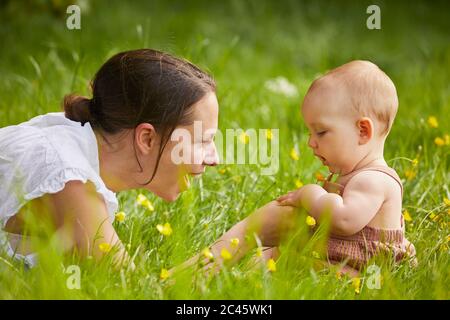 Mutter und Tochter spielen auf einer Wiese. Stockfoto