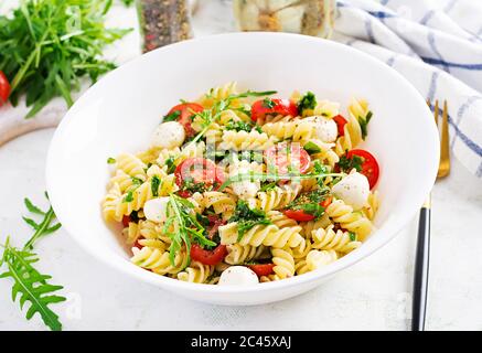 Nudelsalat. Fusilli Pasta - Caprese Salat mit Tomaten, Mozzarella und Basilikum. Stockfoto
