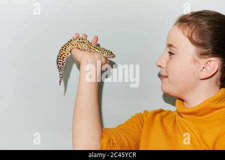 Nahaufnahme von Teenager-Mädchen hält gefleckte Haustier Leopard Gecko. Stockfoto