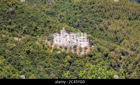 Die Benediktinerabtei von San Cassiano im alten mittelalterlichen Dorf Narni. Umbrien, Terni, Italien. Die grünen Hügel, die vom Wald bedeckt sind. Viele Bäume Stockfoto