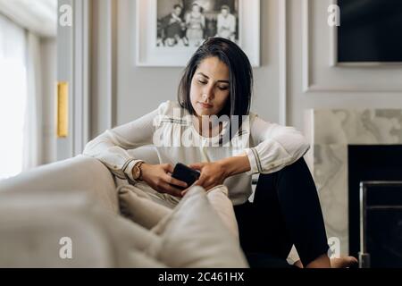 Geschäftsfrau mit Smartphone in der Suite Stockfoto