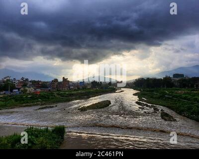 Lalitpur, Nepal. Juni 2020. Monsunwolken schweben während der Sonnenuntergangszeit über dem Bagmati-Fluss, wie man von einer Brücke in Lalitpur, Nepal, am 24. Juni 2020 aus gesehen hat. Kredit: Sunil Sharma/ZUMA Wire/Alamy Live Nachrichten Stockfoto