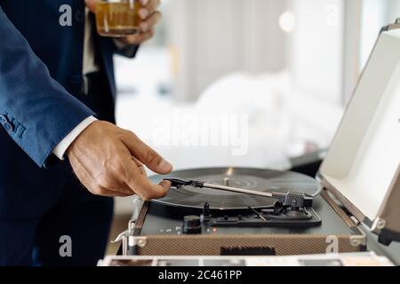 Geschäftsmann mit Eistee trinken, spielen Drehtisch in Suite Stockfoto