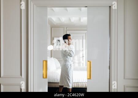 Mann mit Smartphone in der Suite Stockfoto