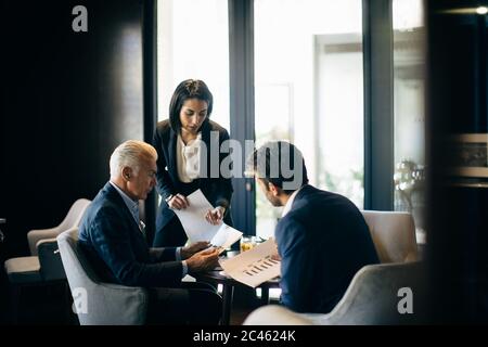 Geschäftsfrau und Männer, Treffen im Hotel Restaurant Stockfoto