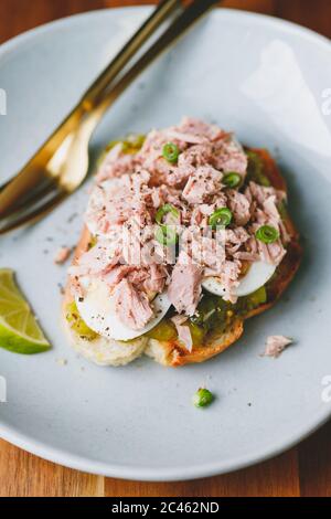 Offenes Sandwich mit Thunfisch aus der Dose, Ei und Gurkendressing mit Limette. Stockfoto