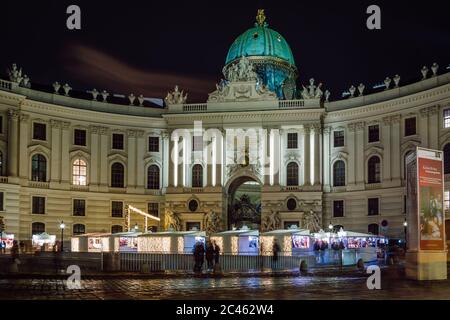 Nachtansicht der Hofburg und der Lichter des Michaelerplatzes Weihnachtsmarkt, Wien, Österreich. Stockfoto