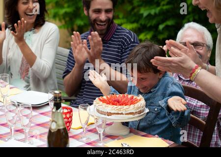 Junge mit Geburtstagstorte überrascht Stockfoto